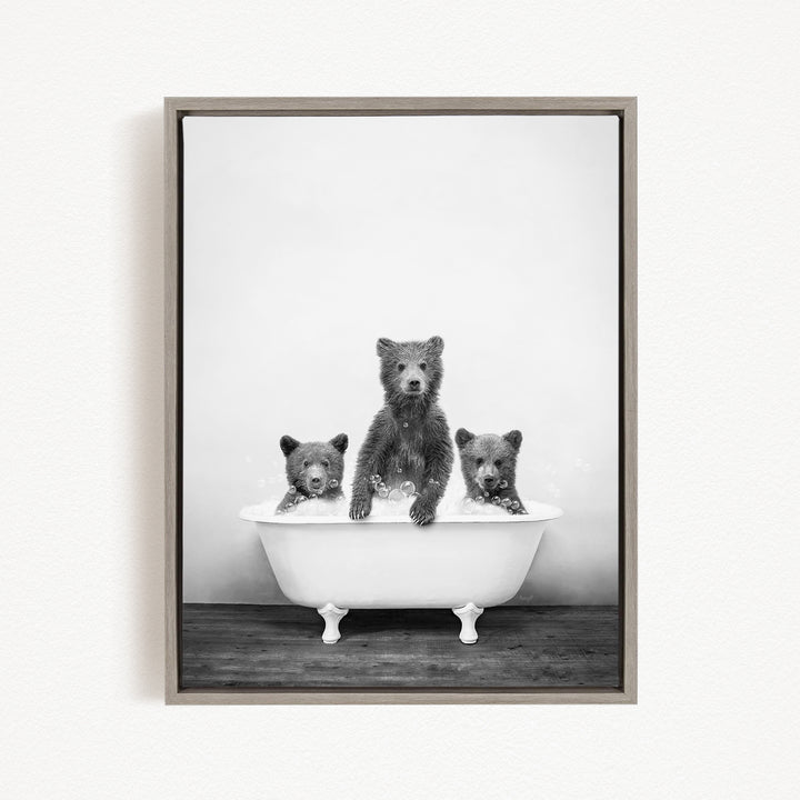 A black and white image of three bears sitting in a bathtub, with one bear sitting in the center and the other two bears sitting on either side.