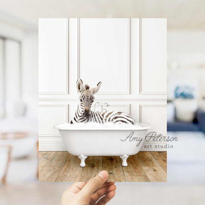 a hand holding a photo of a zebra in a bathtub