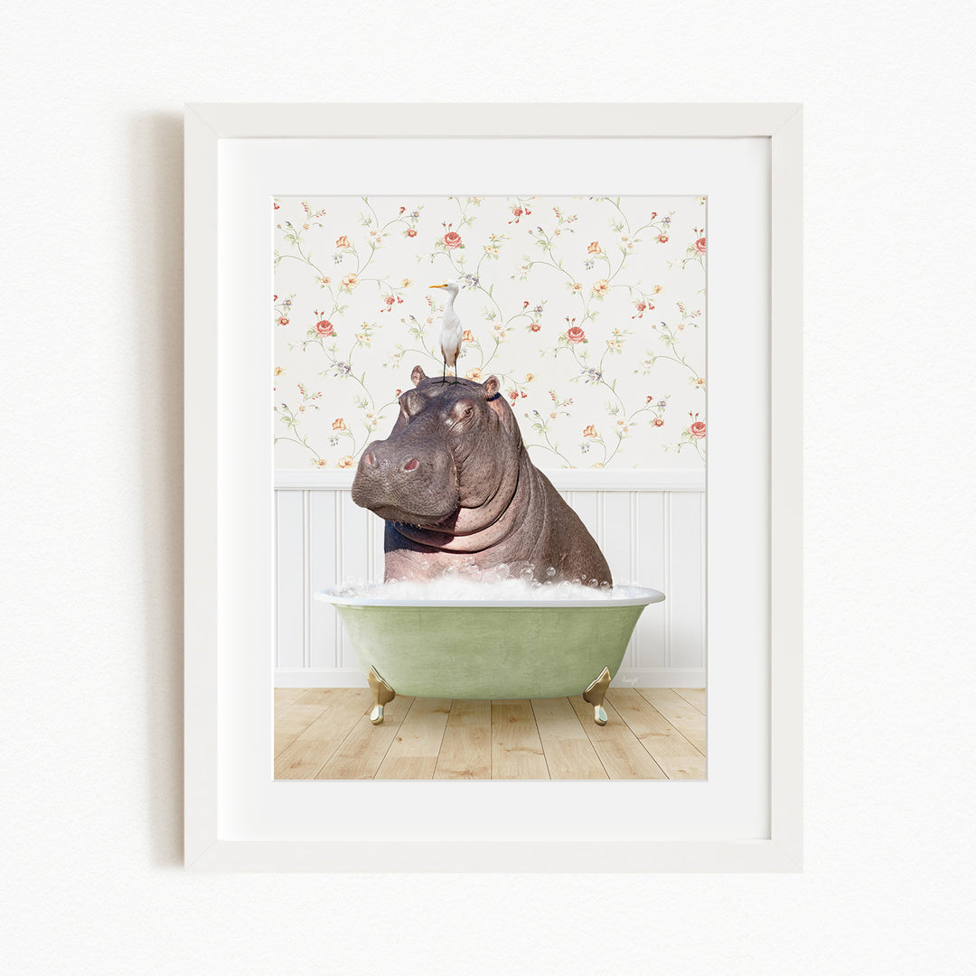 A framed image depicting a hippopotamus sitting in a green bathtub, with a bird perched on its head.