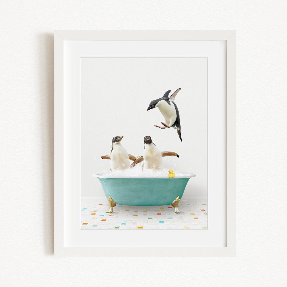 A framed image depicting two penguins sitting in a bathtub filled with bubbles, with one penguin flying towards the other.
