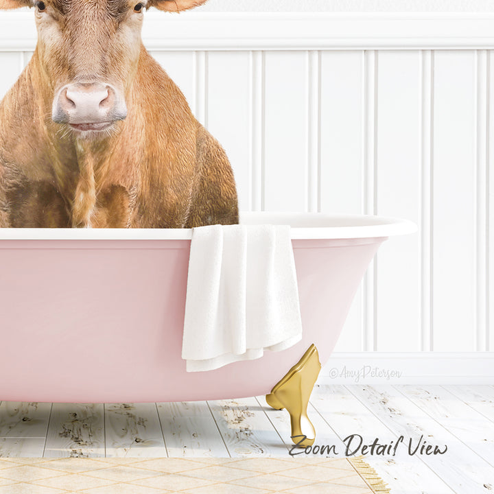 A cow is sitting in a pink bathtub, with a towel and gold object nearby.