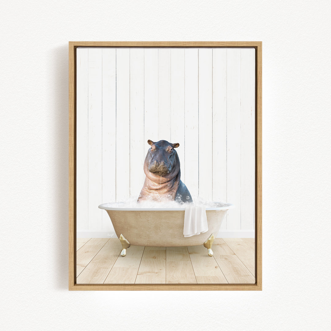 A framed image depicting a hippopotamus sitting in a bathtub filled with water, with a towel hanging from the side of the tub.
