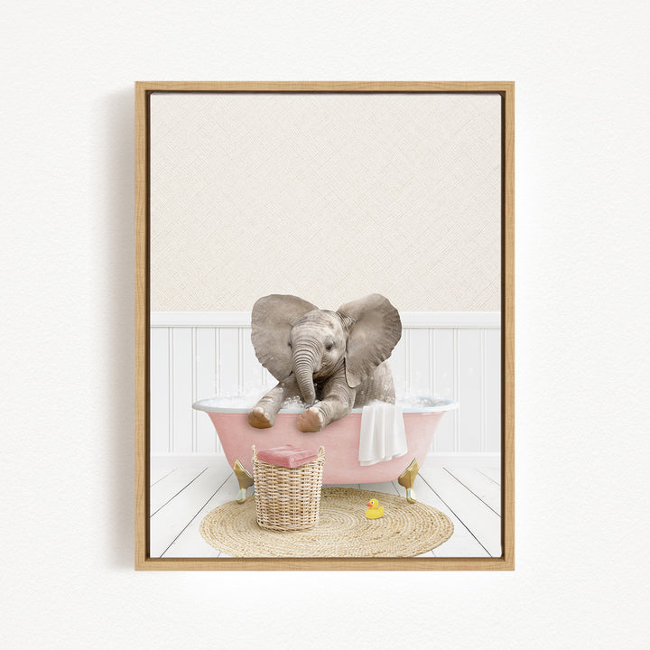 A baby elephant sitting in a pink bathtub, surrounded by a basket of toys and a yellow rubber duck.