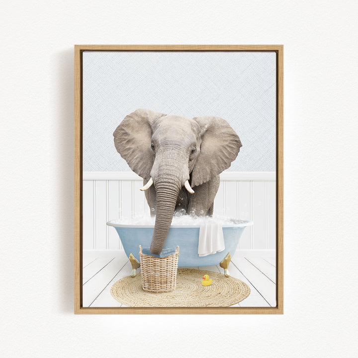 A gray elephant is standing in a blue bathtub filled with water, surrounded by a basket of toys and a yellow rubber duck.