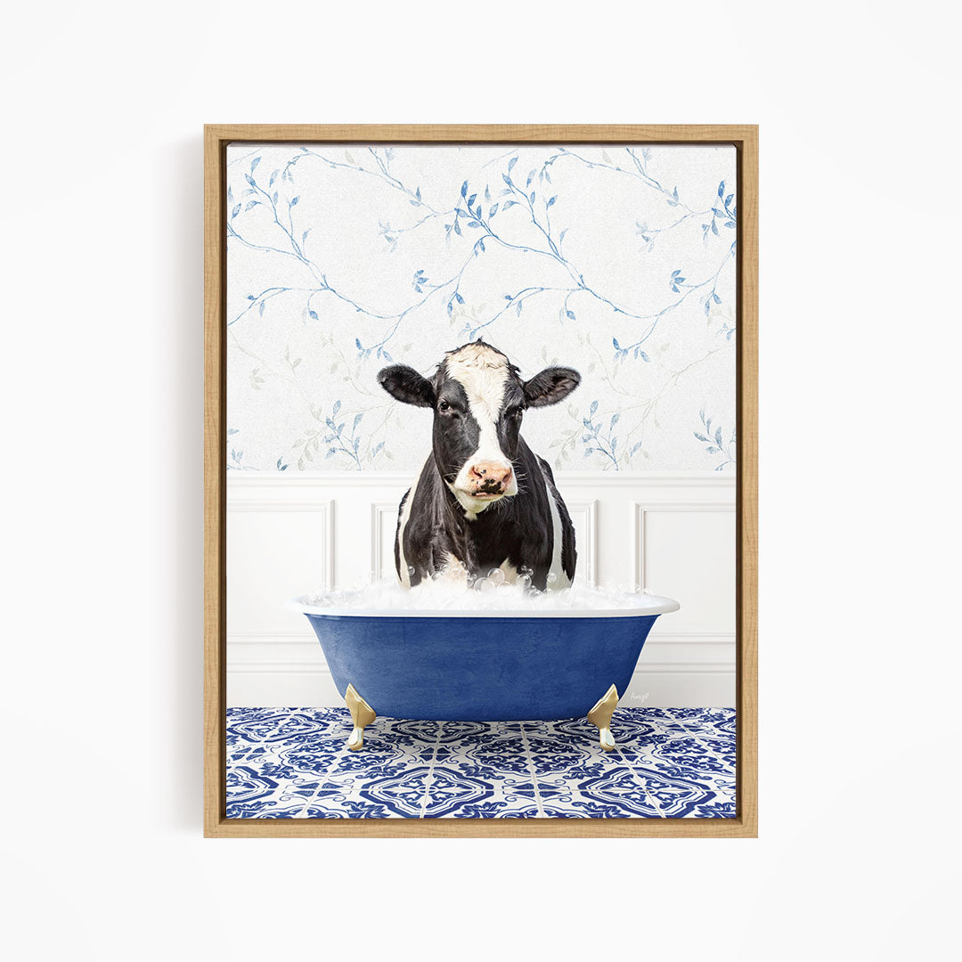 A black and white cow is sitting in a blue bathtub filled with water, surrounded by a blue and white patterned floor.