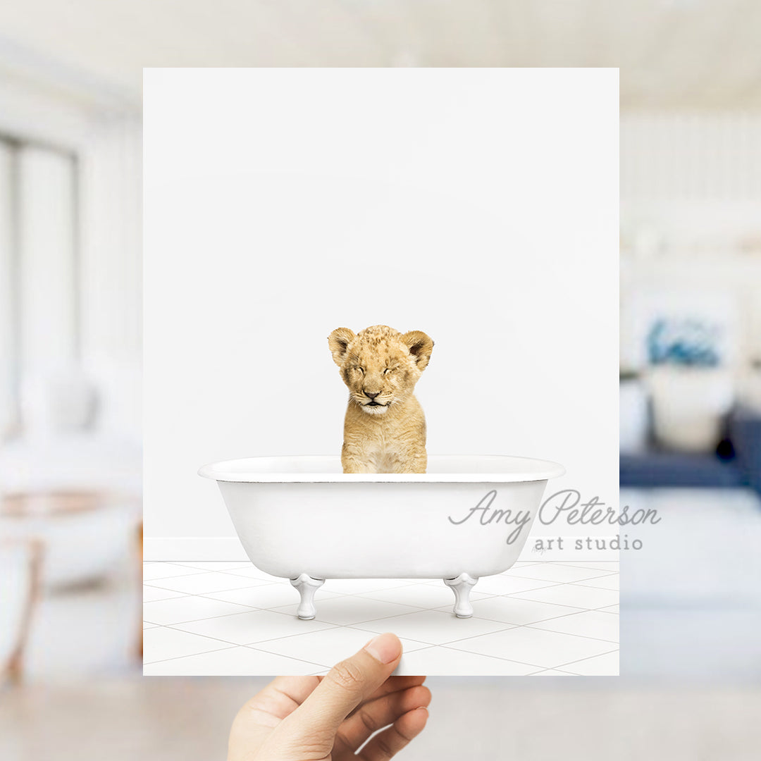 a hand holding a card with a picture of a baby lion in a bathtub