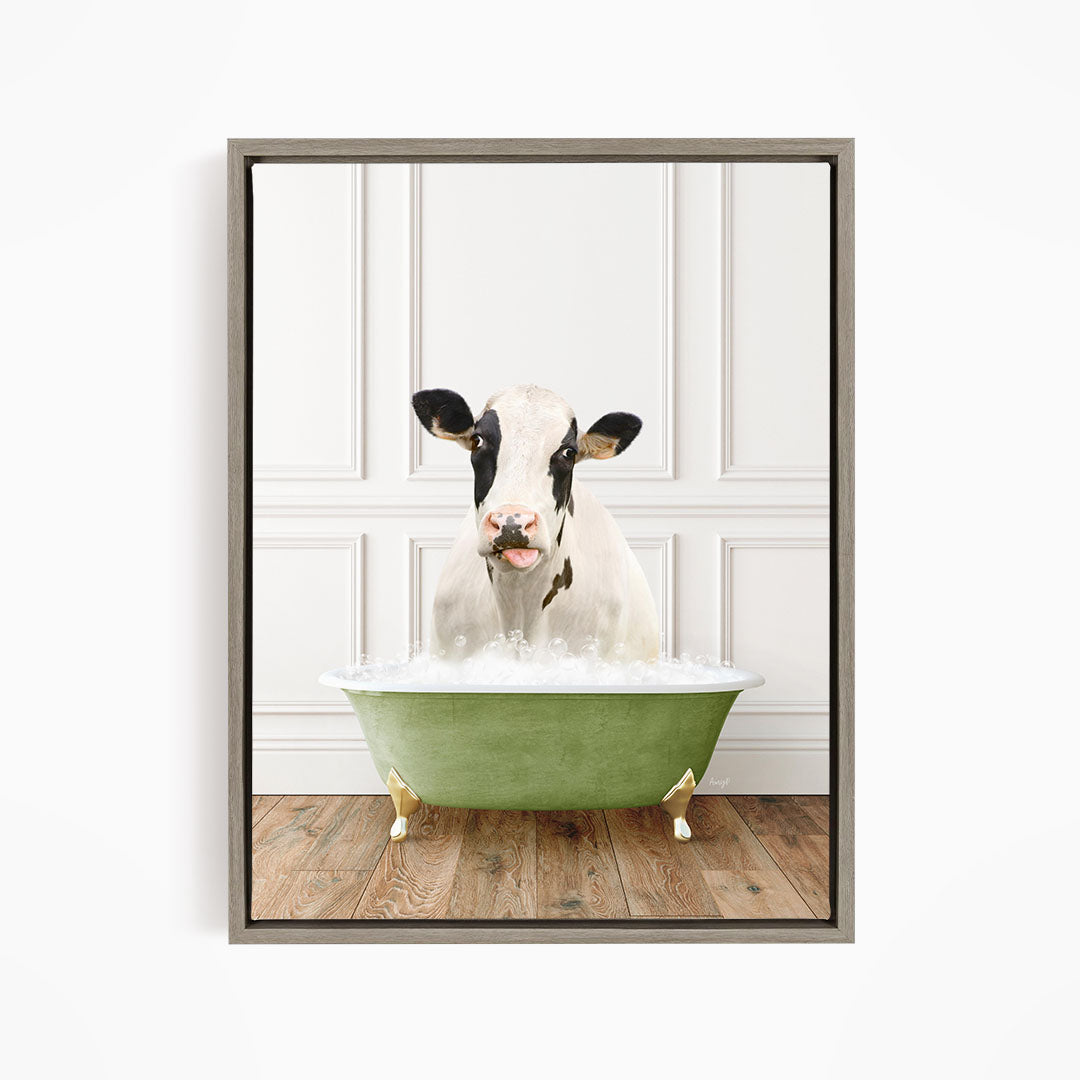 A black and white cow is sitting in a green bathtub filled with bubbles, looking directly at the camera.