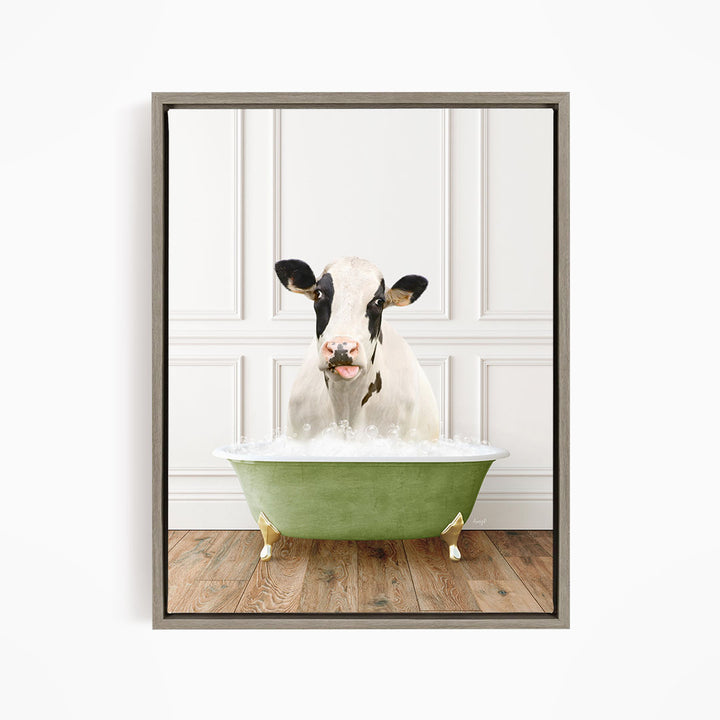 A black and white cow is sitting in a green bathtub filled with bubbles, looking directly at the camera.