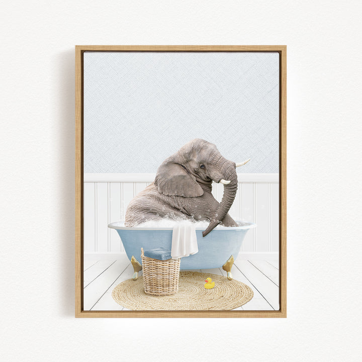 A gray elephant is sitting in a blue bathtub filled with water, surrounded by a basket of toys and a yellow rubber duck.