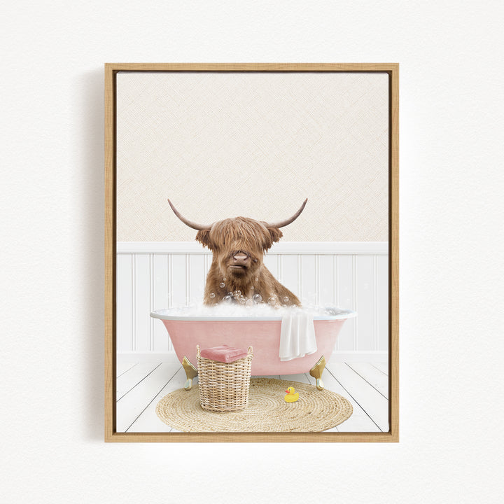 A brown cow with horns is sitting in a pink bathtub filled with bubbles, surrounded by a basket of toys and a yellow rubber duck.