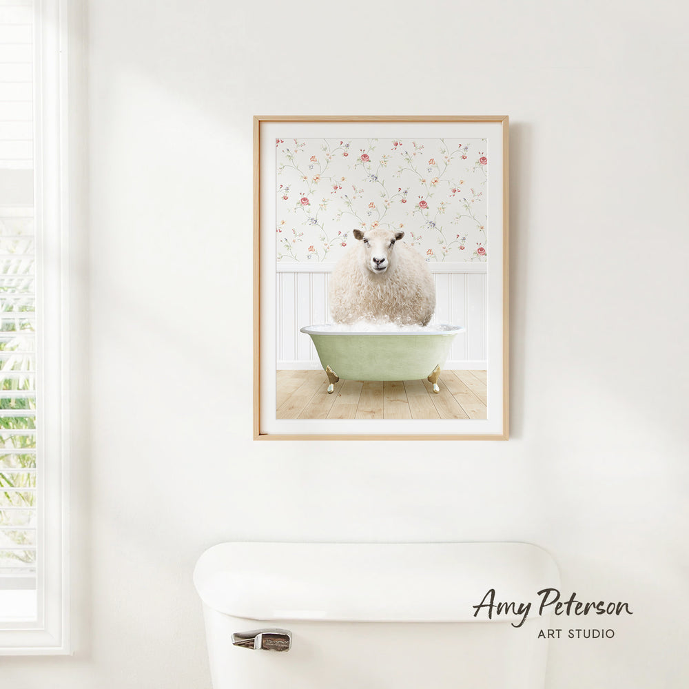 A framed image of a fluffy white sheep sitting in a green bathtub, with a floral pattern on the wall behind it.