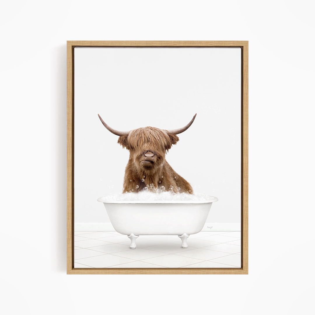 A brown cow with long horns is sitting in a white bathtub filled with water, appearing to enjoy the bath.