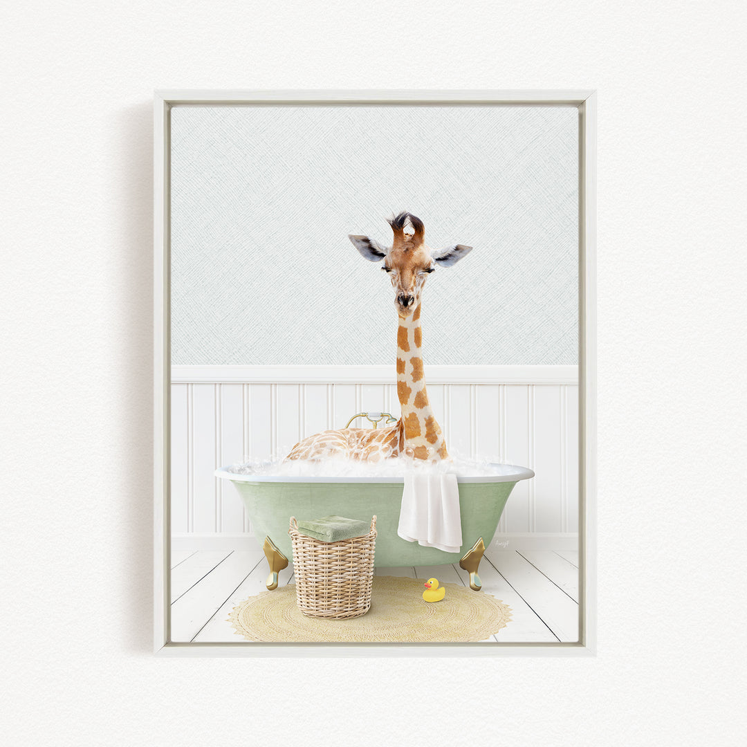 A giraffe is sitting in a green bathtub filled with water, surrounded by a basket of toys and a yellow rubber duck.