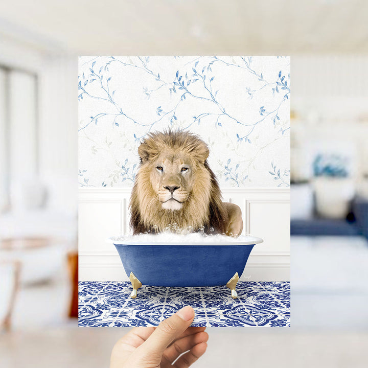 A lion is sitting in a blue bathtub, surrounded by a floral patterned wall.