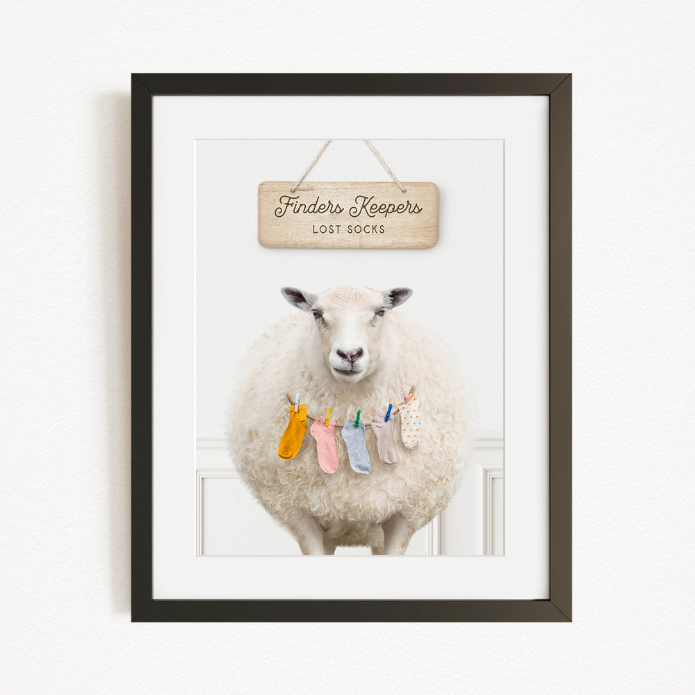A framed image of a sheep wearing colorful socks, with a sign above it that says "Finders Keepers Lost Socks".