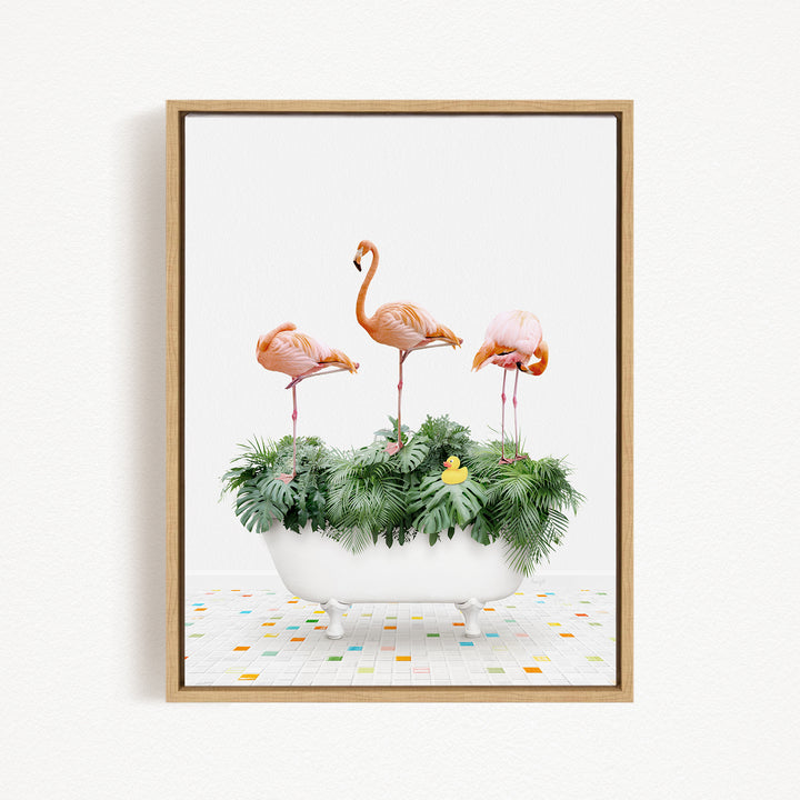A framed image depicting three flamingos standing on a white bathtub filled with green plants and a yellow rubber duck.
