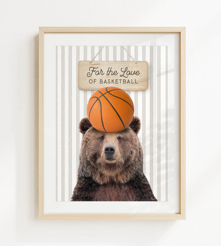 A framed image of a brown bear with a basketball on its head, accompanied by a wooden sign that reads "For the Love of Basketball".