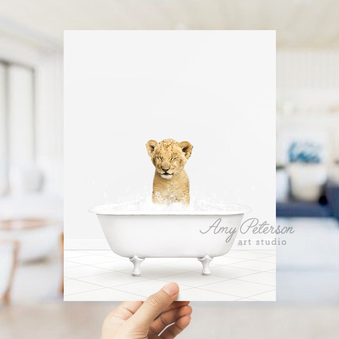 a hand holding a card with a picture of a baby lion in a bathtub