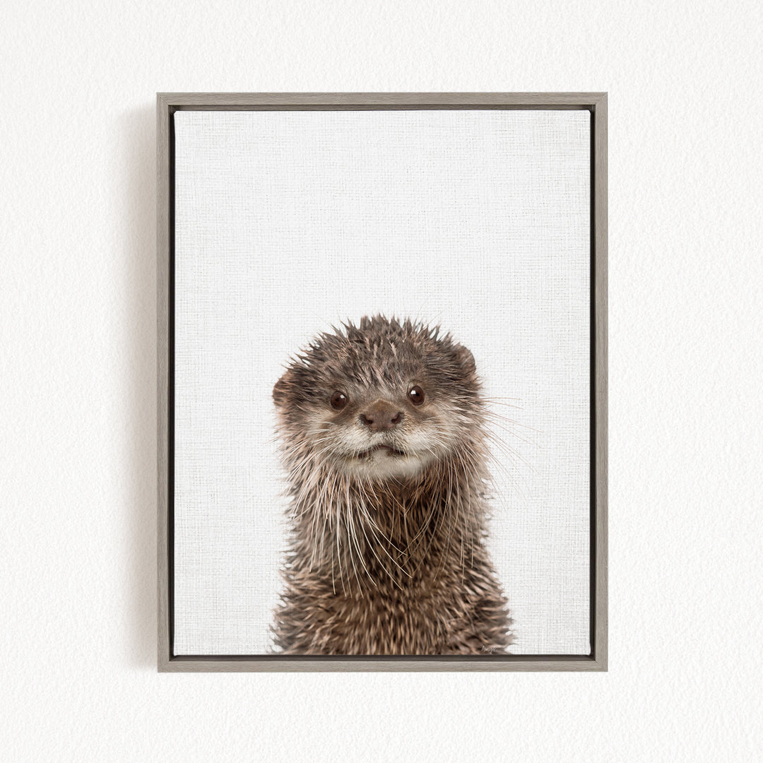 A close-up portrait of an otter with a curious expression, looking directly at the camera.
