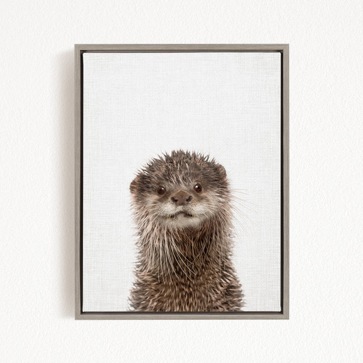 A close-up portrait of an otter with a curious expression, looking directly at the camera.