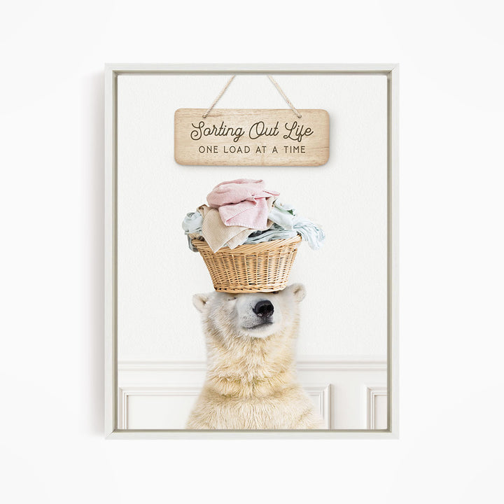 A polar bear balancing a basket of laundry on its head, with a sign above that says "Sorting Out Life One Load at a Time".