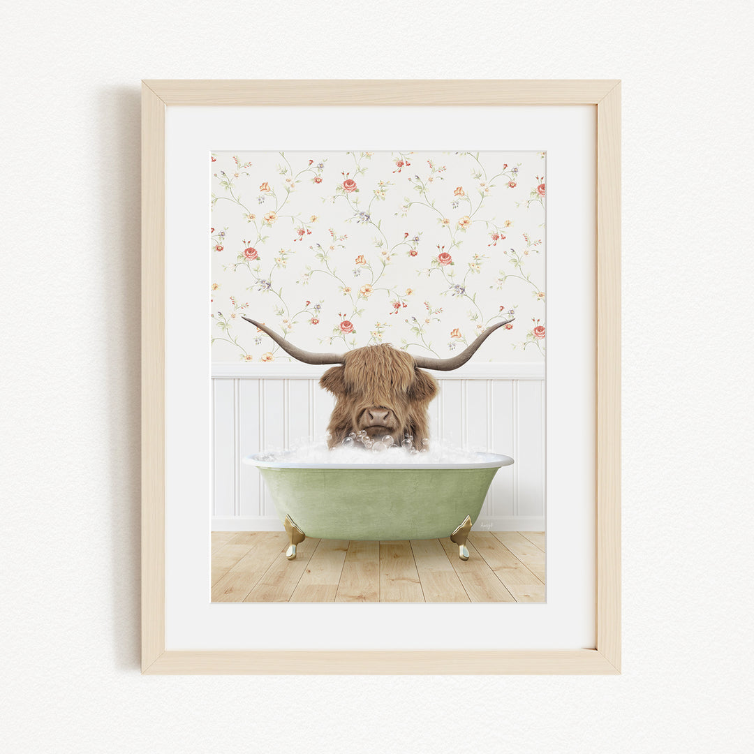 A brown cow with long horns is sitting in a green bathtub, surrounded by a floral wallpaper.