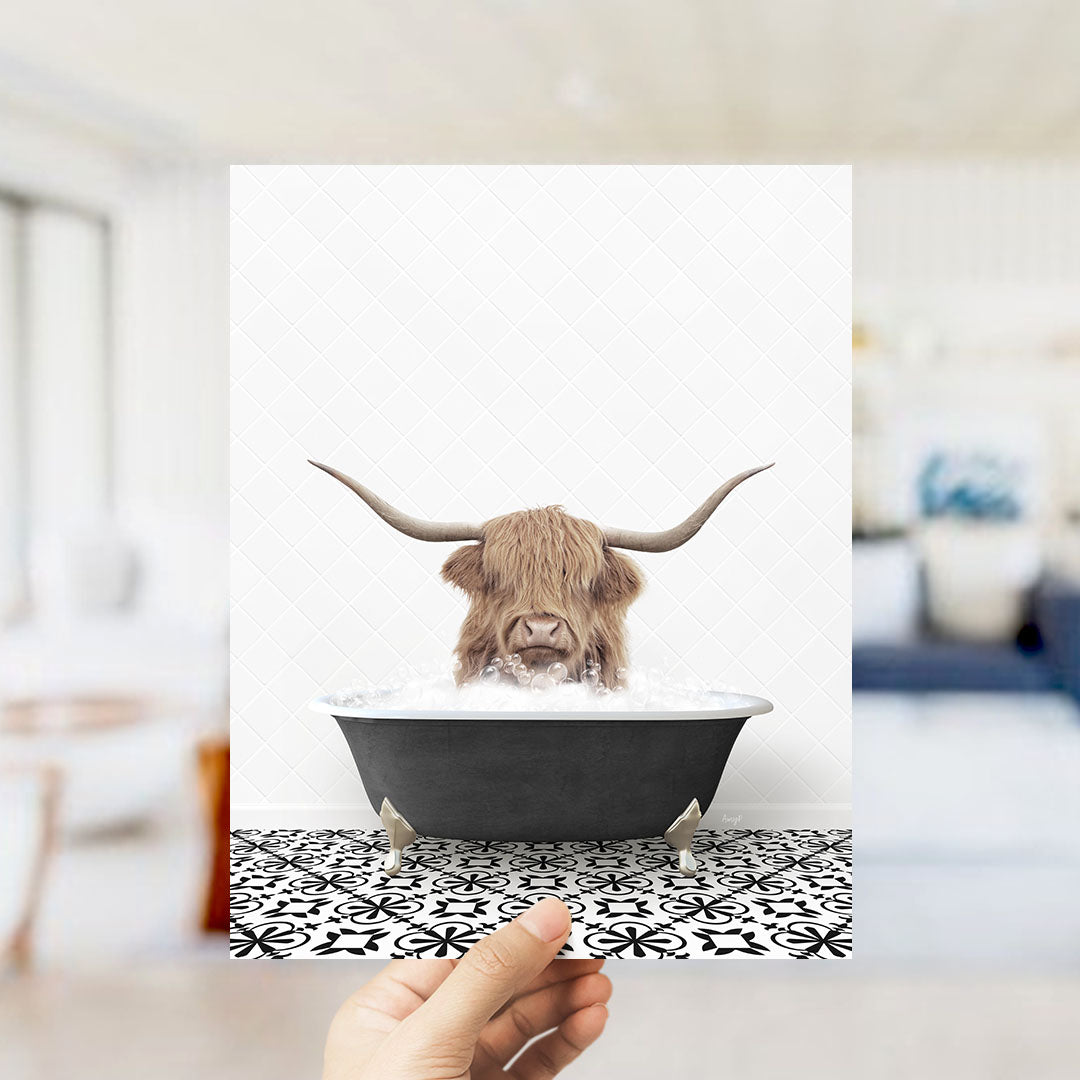 A hand holds up a framed image of a horned animal, likely a yak or a yak, sitting in a bathtub filled with water.
