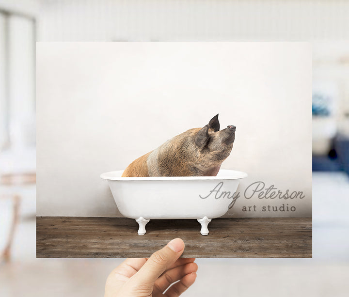 a hand holding a card with a dog in a bathtub