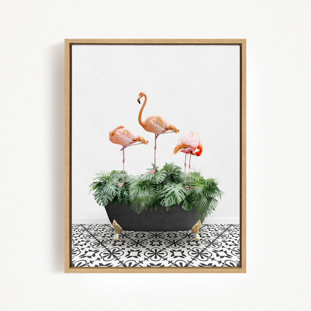 A framed image of three pink flamingos standing in a black planter filled with green plants, placed on a black and white patterned floor.