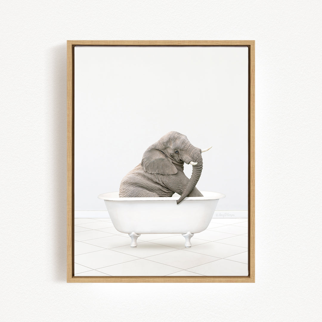 A gray elephant sitting in a white bathtub, with its trunk raised and appearing to be enjoying the bath.