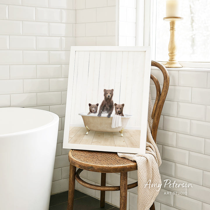 A framed image of three bears sitting in a bathtub, with one bear sitting in the center and the other two bears sitting on either side.