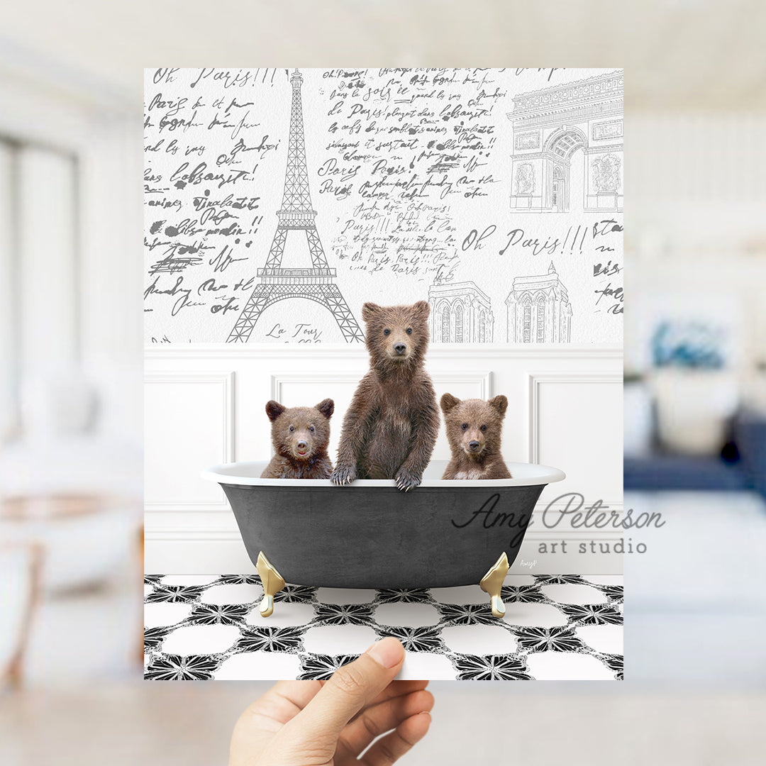 a person holding up a card with three bears in a bathtub