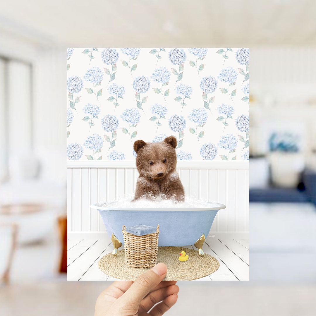 A brown bear sitting in a blue bathtub filled with bubbles, surrounded by a floral patterned wall.