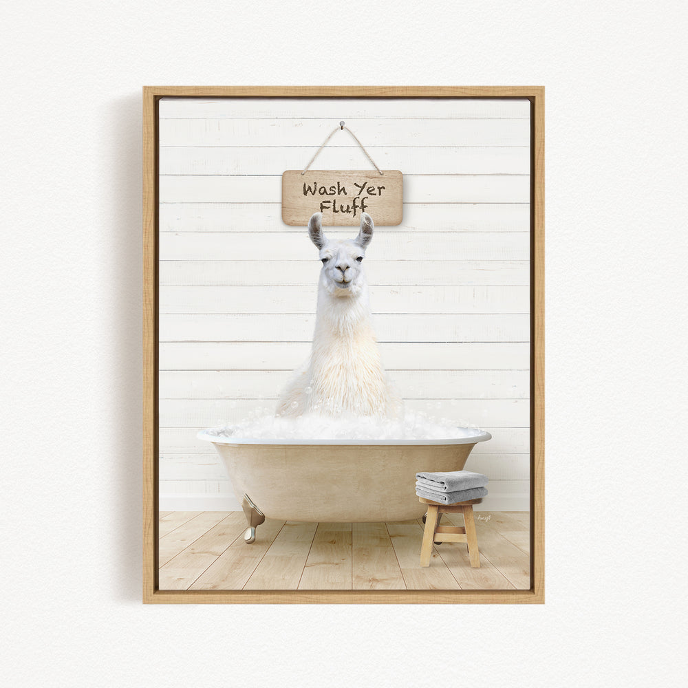 A white llama sitting in a bathtub, with a wooden sign above it that says "Wash yer Fluff".