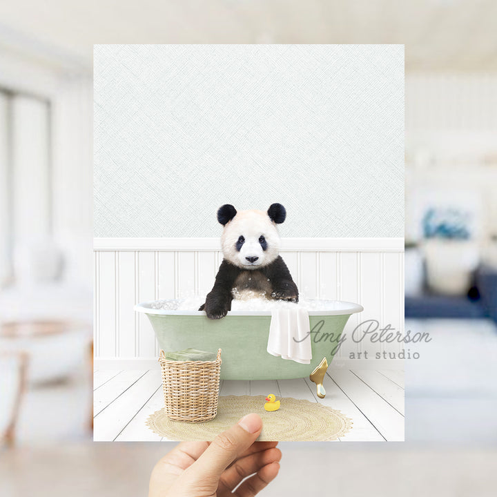 a hand holding a card with a panda bear in a bathtub