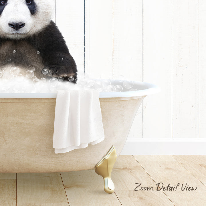 A panda bear sitting in a bathtub filled with bubbles, with a towel and gold bathtub leg visible.