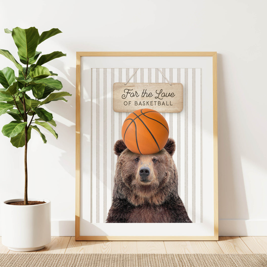 A framed image of a brown bear holding a basketball in its head, with a sign above it that says "For the Love of Basketball".