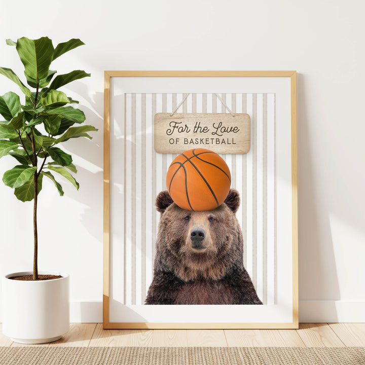 A framed image of a brown bear holding a basketball in its head, with a sign above it that says "For the Love of Basketball".