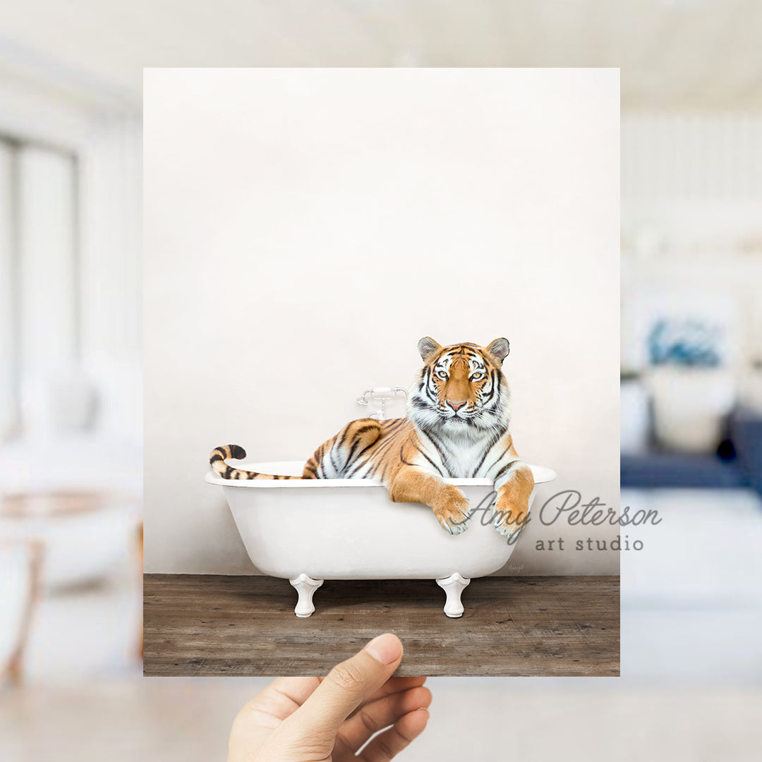 a hand holding up a picture of a tiger in a bathtub