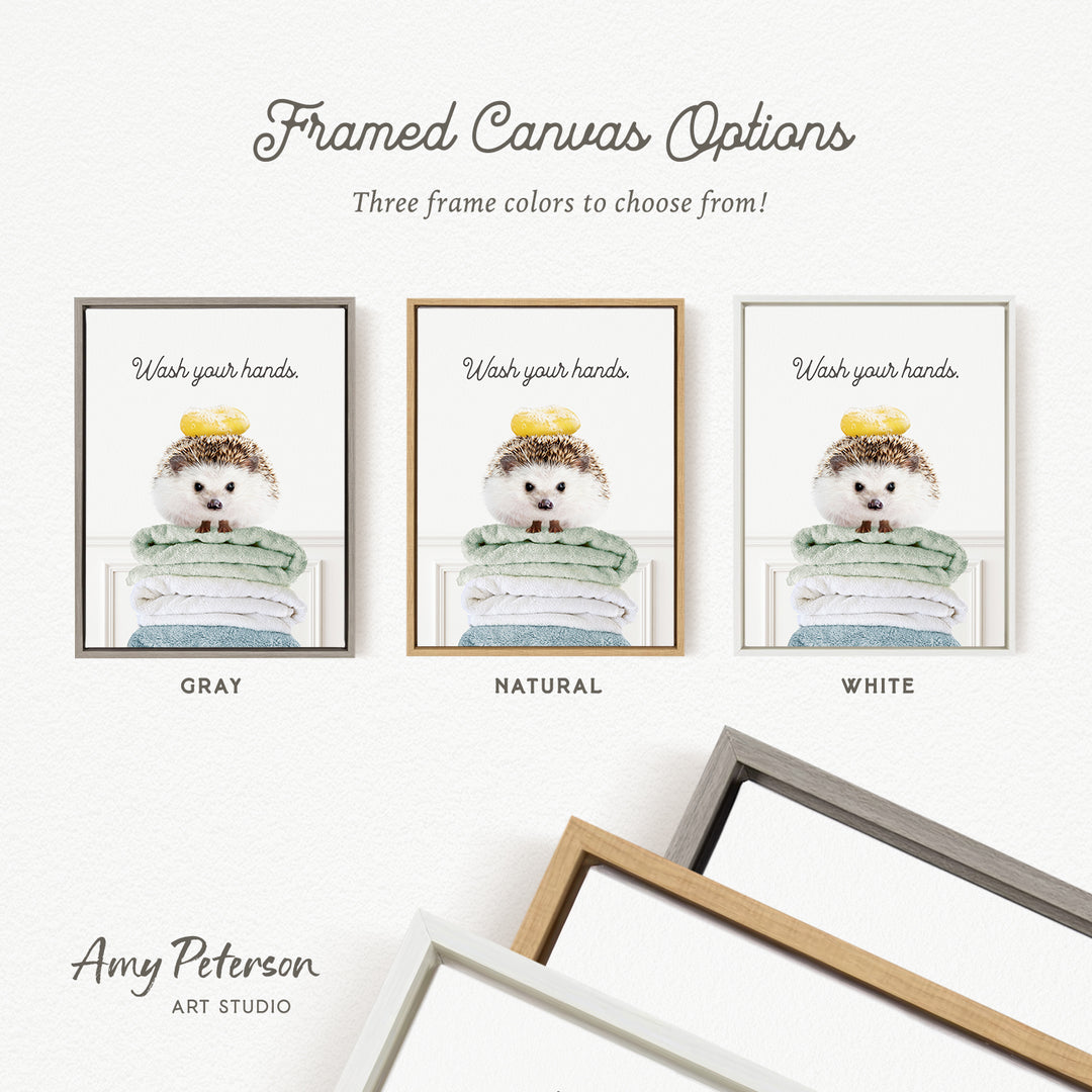 The image is a framed canvas with three different color options for the frame, including gray, natural, and white. The canvas features a picture of a hedgehog with a yellow bow on its head, and the text "Wash your hands" is displayed above the hedgehog.
