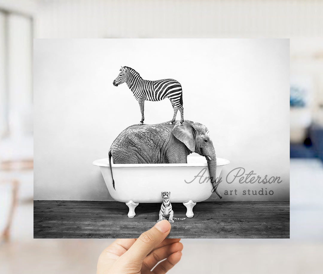 a person holding up a picture of a zebra and an elephant in a bathtub