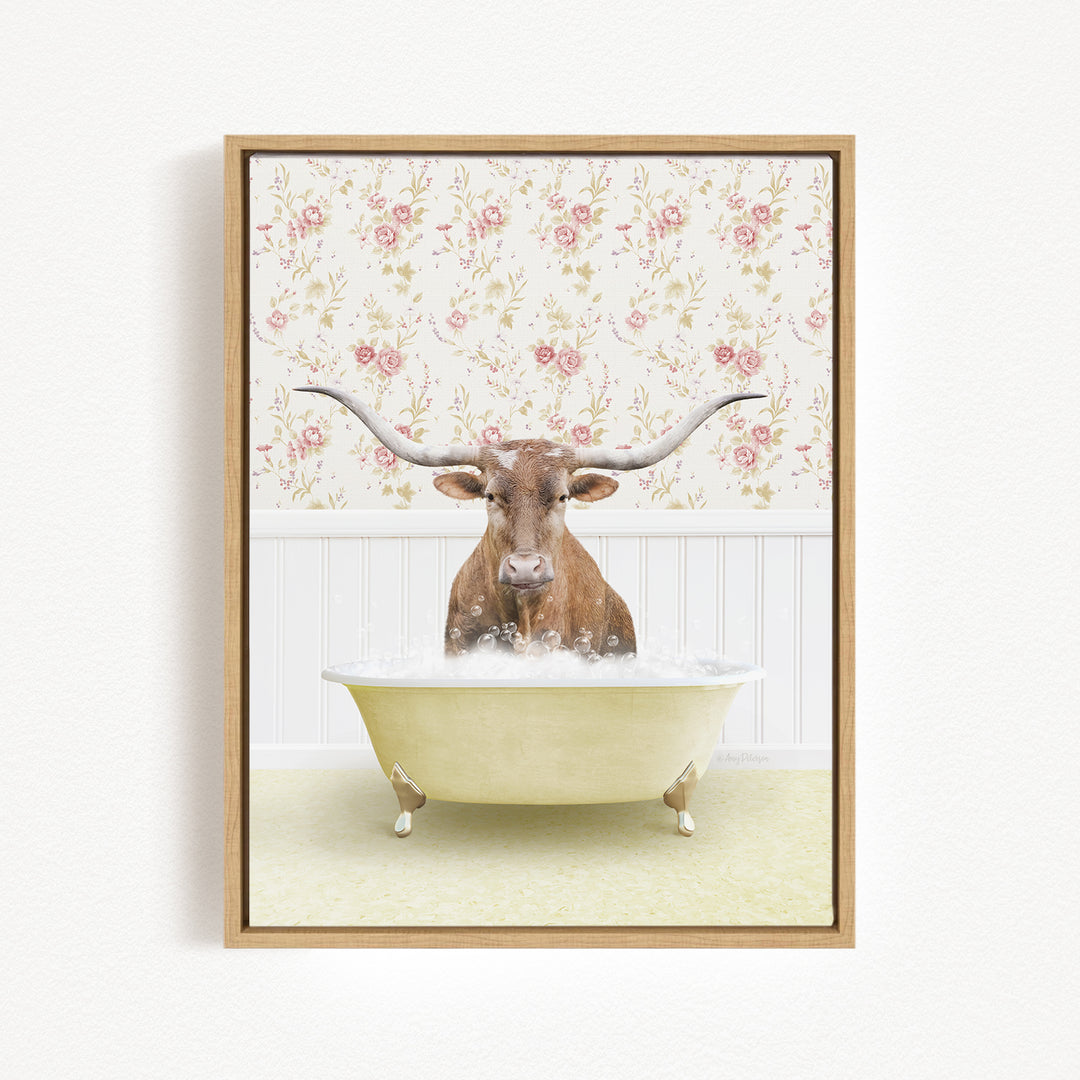 A brown cow with long horns is sitting in a white bathtub filled with bubbles, against a floral wallpaper background.
