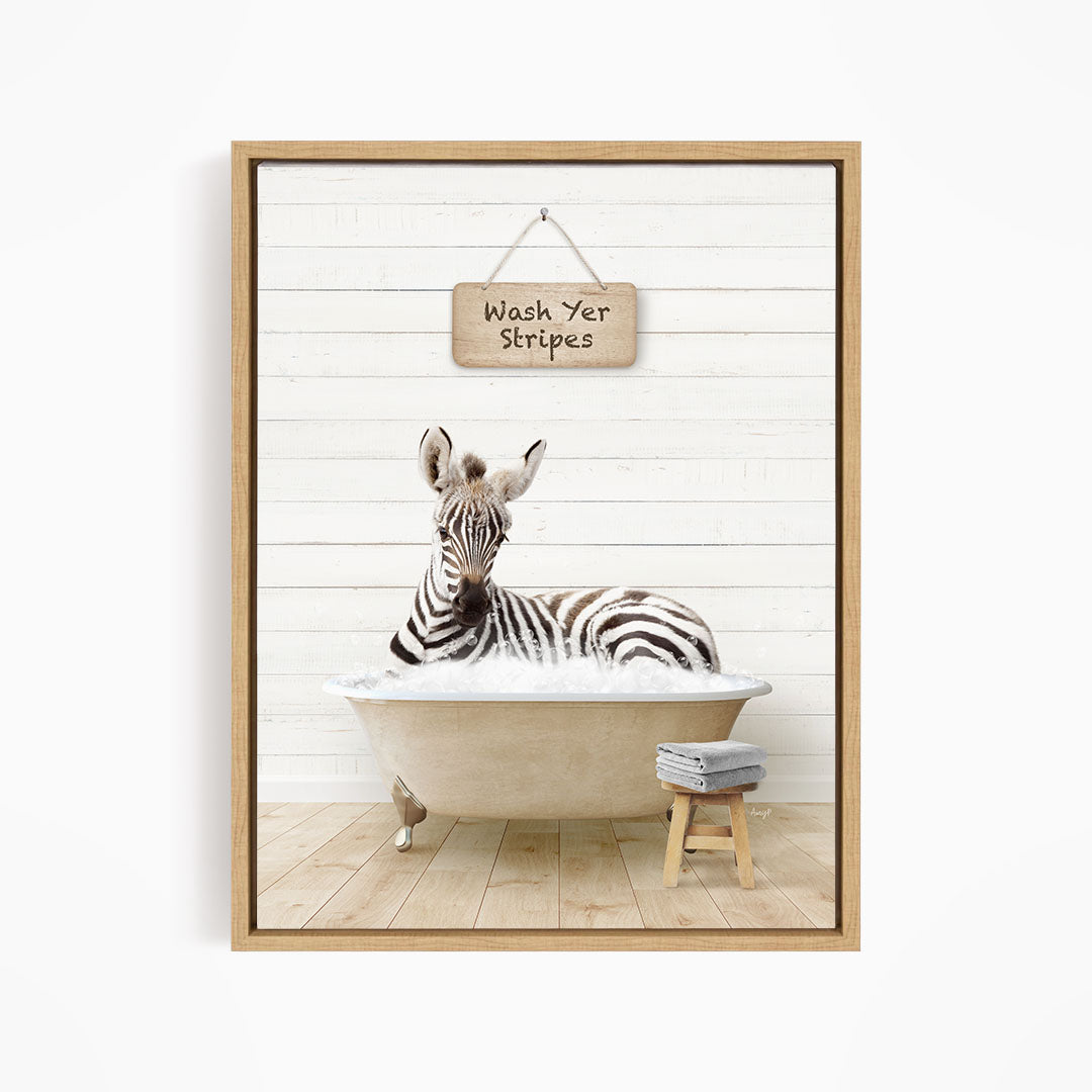 A zebra is sitting in a bathtub, with a sign above it that says "Wash Yer Stripes".