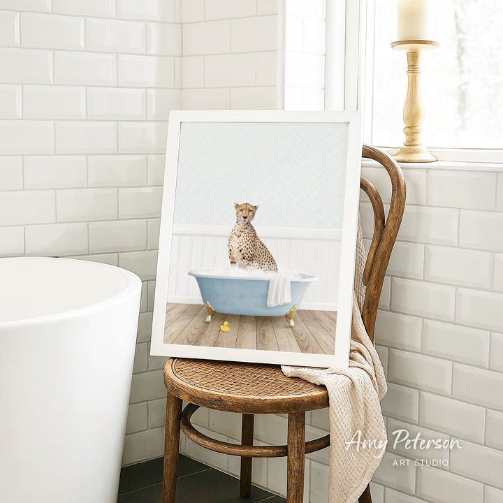A cheetah sitting in a blue bathtub, surrounded by white tiles, in a bathroom setting.