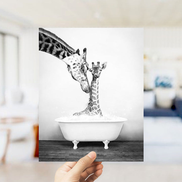 A hand holds up a black and white photograph of two giraffes in a bathtub, with one giraffe partially submerged in the water.