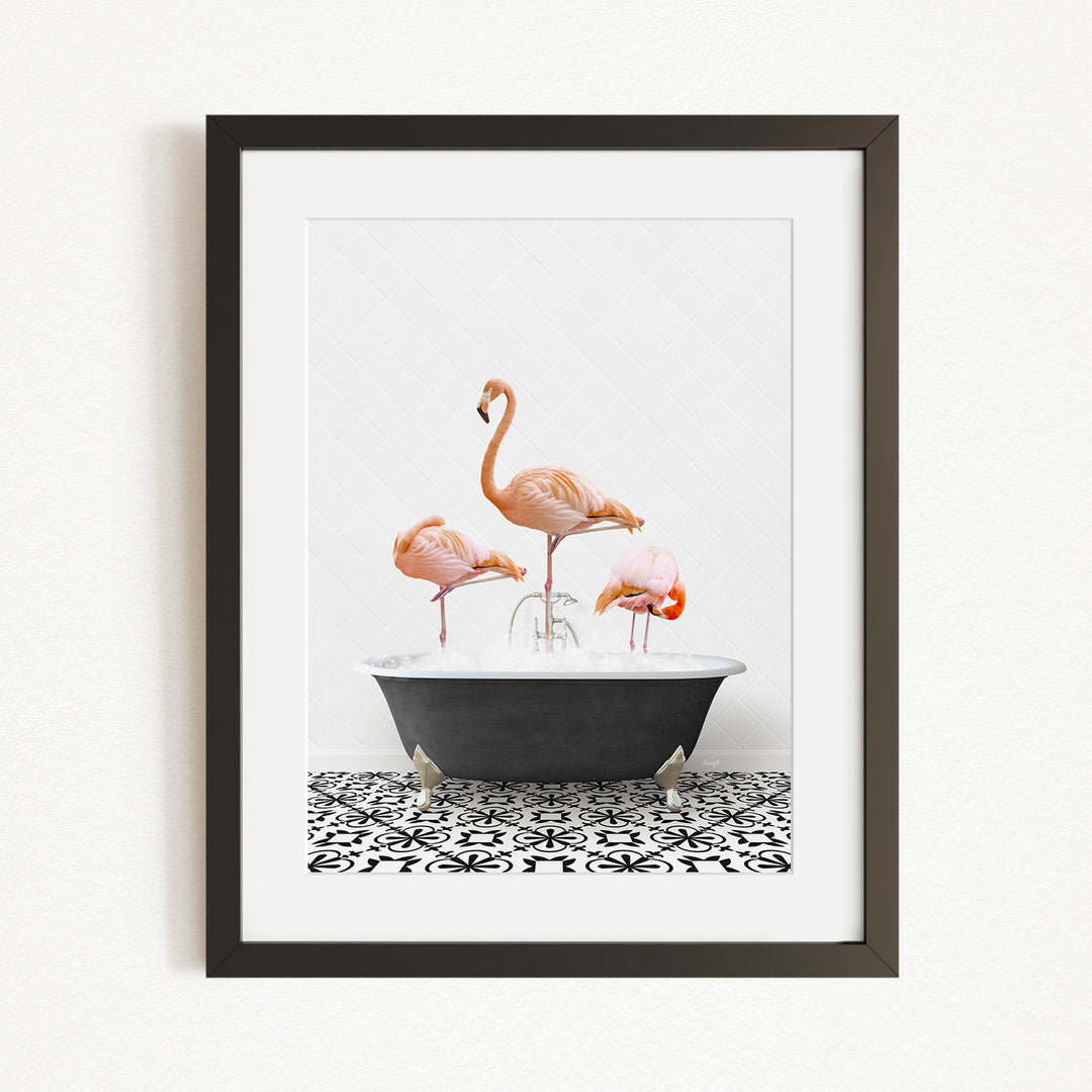 A framed image depicting three flamingos standing in a bathtub filled with water.