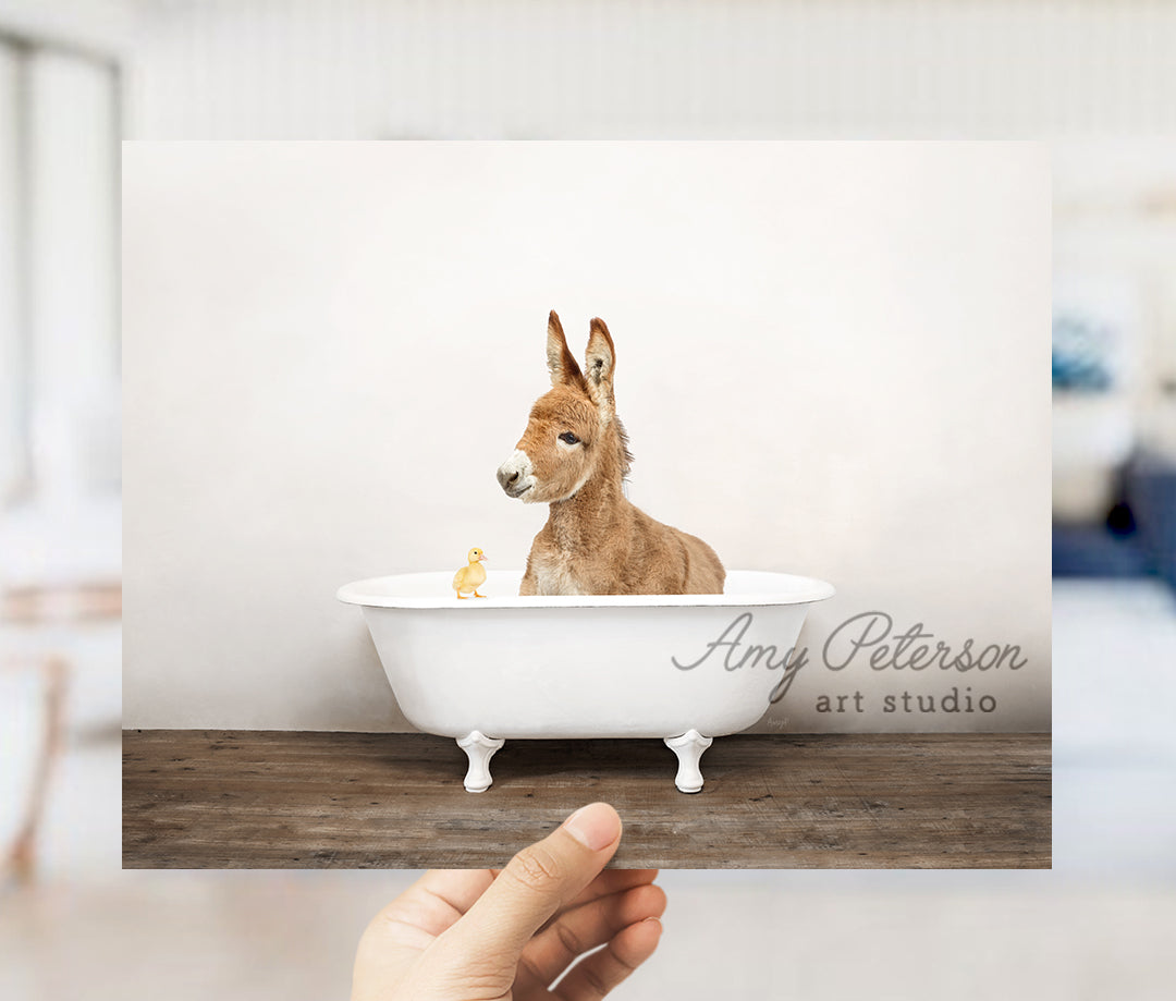 a hand holding up a card with a picture of a donkey in a bathtub