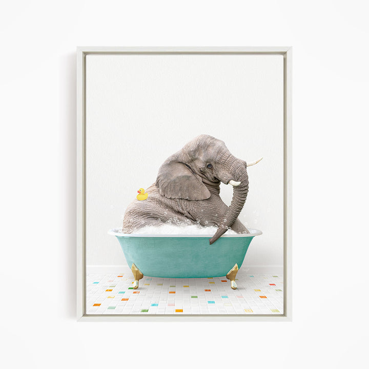 A gray elephant is sitting in a blue bathtub, with a yellow rubber duck floating on its back.