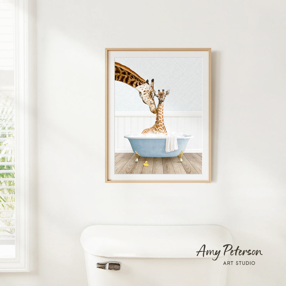 A framed illustration of two giraffes sitting in a bathtub, with one giraffe appearing to be giving the other a bath.