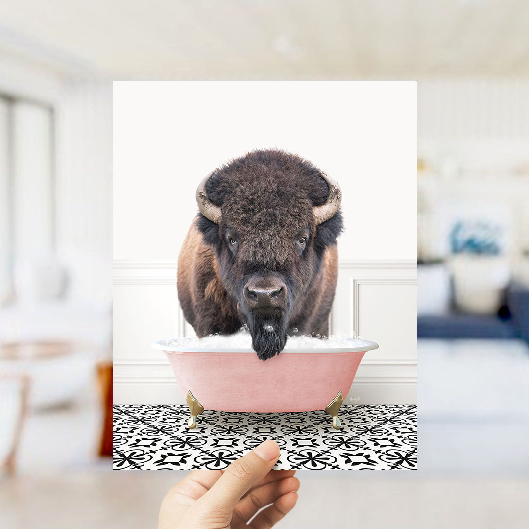 A large, furry bison with horns is standing in a pink bathtub filled with bubbles, creating a whimsical and unexpected scene.